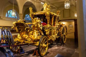 Prunkvolle Gold State Coach aus vergoldetem Holz mit detailreichen Schnitzereien von Tritonen in den Royal Mews London.