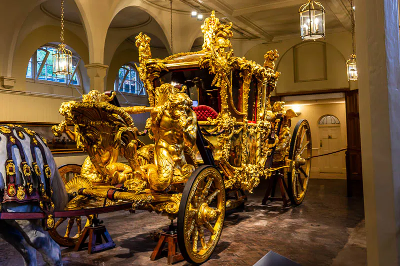 Prunkvolle Gold State Coach aus mit Blattgold vergoldetem Holz mit detailreichen Schnitzereien von Tritonen in den Royal Mews London.