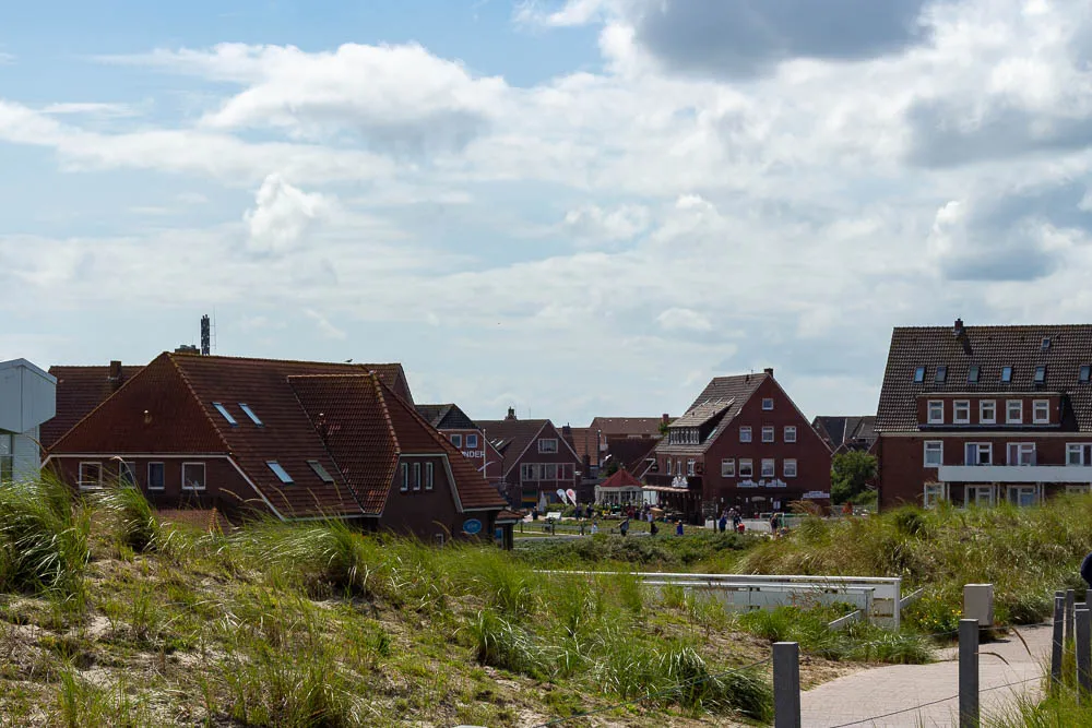 Blick über Dünen auf das Inseldorf von Baltrum.