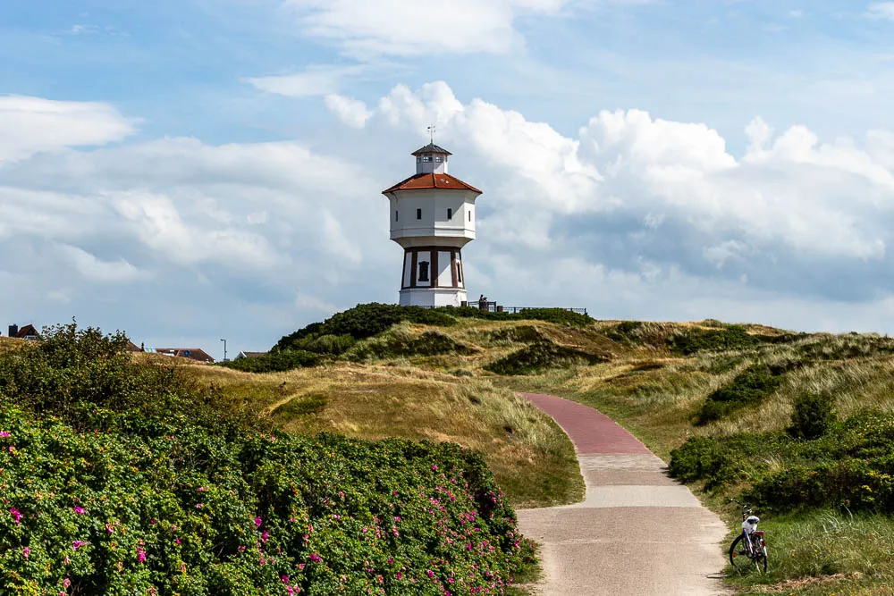 Der Wasserturm von Langeoog steht auf einer Düne oberhalb eines Weges durch die Dünen.